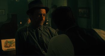 Movie still from “Matewan” (1987), directed by John Sayles – A man wearing a hat talking to another man; Medium shot, Over the shoulder angle