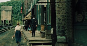Movie still from “Matewan” (1987), directed by John Sayles – A man walking down the sidewalk of a city street; Wide shot, High angle