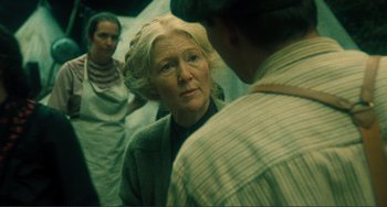 Movie still from “Matewan” (1987), directed by John Sayles – An older woman looking at a younger man in the mirror; Close Up shot, Over the shoulder angle