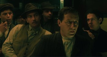 Movie still from “Matewan” (1987), directed by John Sayles – A group of men standing next to each other in a room; Medium shot, Low angle