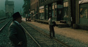 Movie still from “Matewan” (1987), directed by John Sayles – A man standing on a train track next to train tracks; Extreme Wide shot, Over the shoulder angle
