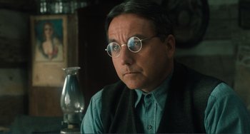 Movie still from “Matewan” (1987), directed by John Sayles – An older man wearing glasses sitting in front of a table; Close Up shot, Low angle