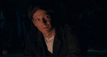 Movie still from “Matewan” (1987), directed by John Sayles – A man wearing a hat and a black jacket; Close Up shot, Over the shoulder angle