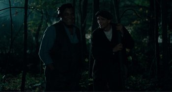 Movie still from “Matewan” (1987), directed by John Sayles – Two men standing next to each other in the woods; Medium shot, Over the shoulder angle