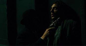 Movie still from “Matewan” (1987), directed by John Sayles – A man holding a pair of pipes in a dark room; Close Up shot, Low angle