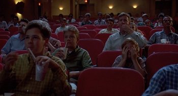 Movie still from “Matinee” (1993), directed by Joe Dante – A group of people sitting in a movie theater; Medium shot, High angle