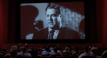 Movie still from “Matinee” (1993), directed by Joe Dante – People sitting in a movie theater watching a movie; Wide shot, High angle