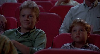 Movie still from “Matinee” (1993), directed by Joe Dante – Two young boys sitting in a movie theater watching a movie; Medium shot, High angle