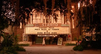 Movie still from “Matinee” (1993), directed by Joe Dante – A woman walking in front of a movie theater; Extreme Wide shot, Low angle