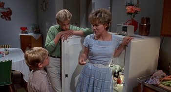 Movie still from “Matinee” (1993), directed by Joe Dante – A woman and two young boys standing in front of an open refrigerator; Medium shot, Over the shoulder angle