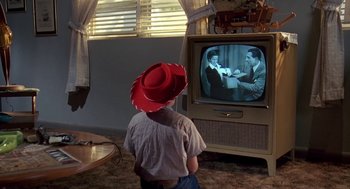 Movie still from “Matinee” (1993), directed by Joe Dante – A man wearing a cowboy hat watching television; Medium shot, High angle