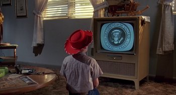 Movie still from “Matinee” (1993), directed by Joe Dante – A young boy wearing a cowboy hat watching television; Close Up shot, Low angle