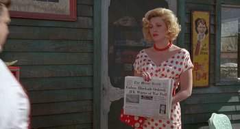 Movie still from “Matinee” (1993), directed by Joe Dante – A woman in a polka dot dress holding a newspaper; Medium shot, Low angle