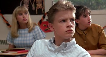 Movie still from “Matinee” (1993), directed by Joe Dante – A young boy is sitting in front of a group of people; Close Up shot, Low angle
