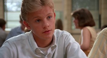 Movie still from “Matinee” (1993), directed by Joe Dante – A young man sitting in front of a window; Close Up shot, Low angle