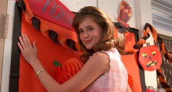 Movie still from “Matinee” (1993), directed by Joe Dante – A young girl posing in front of a wall of pumpkins; Close Up shot, Low angle