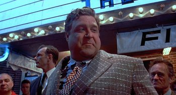Movie still from “Matinee” (1993), directed by Joe Dante – A man in a suit and a tie; Medium shot, Low angle