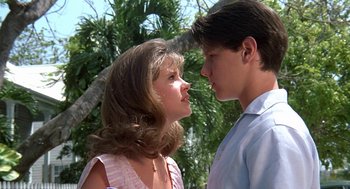 Movie still from “Matinee” (1993), directed by Joe Dante – A man and a woman standing next to each other; Close Up shot, Over the shoulder angle