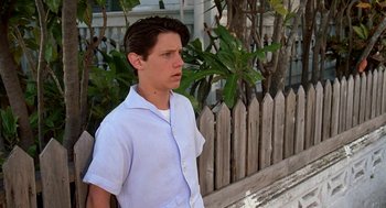 Movie still from “Matinee” (1993), directed by Joe Dante – A young man standing in front of a wooden fence; Medium shot, Low angle