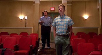 Movie still from “Matinee” (1993), directed by Joe Dante – Two men standing in an empty room with red seats; Wide shot, Low angle