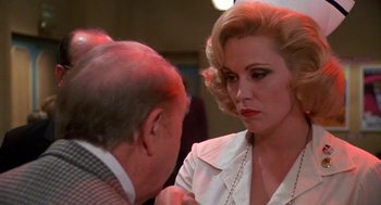 Movie still from “Matinee” (1993), directed by Joe Dante – An older man and a younger woman are talking to each other; Close Up shot, Over the shoulder angle