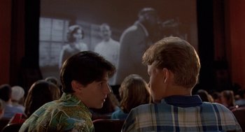 Movie still from “Matinee” (1993), directed by Joe Dante – Two young men talking in front of a projection screen; Close Up shot, Over the shoulder angle