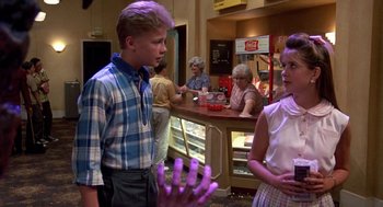Movie still from “Matinee” (1993), directed by Joe Dante – A man and a woman standing in front of an ice cream shop; Medium shot, Over the shoulder angle
