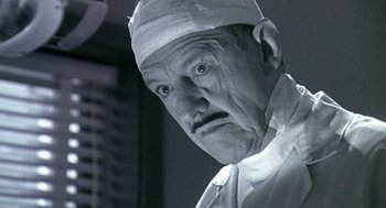 Movie still from “Matinee” (1993), directed by Joe Dante – An old man wearing a surgical cap and a white coat; Close Up shot, Low angle