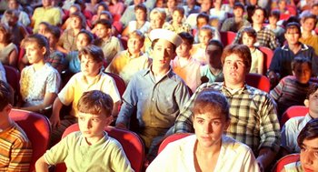 Movie still from “Matinee” (1993), directed by Joe Dante – A group of people sitting in a room; Medium shot, High angle
