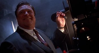 Movie still from “Matinee” (1993), directed by Joe Dante – A person wearing a suit and tie; Close Up shot, Low angle