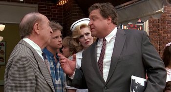 Movie still from “Matinee” (1993), directed by Joe Dante – A group of people standing next to each other in a room; Medium shot, Over the shoulder angle