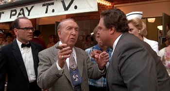 Movie still from “Matinee” (1993), directed by Joe Dante – Two men in suits and ties talking to each other; Medium shot, Over the shoulder angle