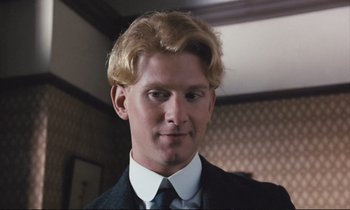 Movie still from “Maurice” (1987), directed by James Ivory – A man with blonde hair wearing a suit and tie; Close Up shot, High angle