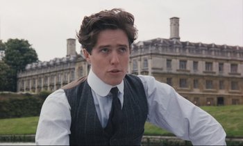 Movie still from “Maurice” (1987), directed by James Ivory – A man in a vest and tie standing in front of a building; Close Up shot, Over the shoulder angle