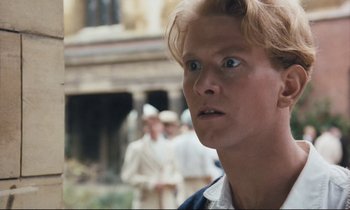 Movie still from “Maurice” (1987), directed by James Ivory – A person looking at the camera; Close Up shot, Low angle