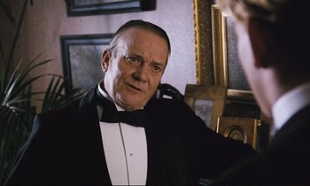 Movie still from “Maurice” (1987), directed by James Ivory – An older man in a tuxedo sitting in front of a mirror; Close Up shot, Over the shoulder angle