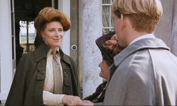 Movie still from “Maurice” (1987), directed by James Ivory – A group of people standing next to each other on a sidewalk; Medium shot, Over the shoulder angle