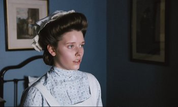 Movie still from “Maurice” (1987), directed by James Ivory – A young woman in a blue dress and a white hat; Close Up shot, Low angle