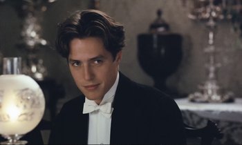 Movie still from “Maurice” (1987), directed by James Ivory – A young man in a tuxedo posing for a picture; Close Up shot, High angle