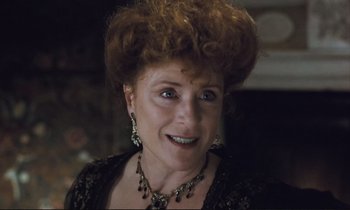 Movie still from “Maurice” (1987), directed by James Ivory – An older woman wearing a necklace and a black dress; Close Up shot, Low angle