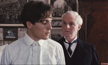 Movie still from “Maurice” (1987), directed by James Ivory – A young man and an older man standing next to each other; Close Up shot, Over the shoulder angle