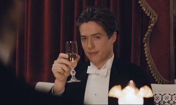 Movie still from “Maurice” (1987), directed by James Ivory – A man in a tuxedo holding a glass of wine; Close Up shot, Over the shoulder angle
