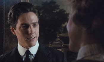 Movie still from “Maurice” (1987), directed by James Ivory – A man in a suit and tie talking to another man in a suit and tie; Close Up shot, Over the shoulder angle