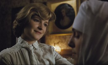 Movie still from “Maurice” (1987), directed by James Ivory – A young boy and a young girl are sitting in a living room; Close Up shot, Low angle