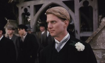 Movie still from “Maurice” (1987), directed by James Ivory – A man in a suit and a white flower in his lapel; Close Up shot, Low angle