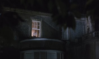 Movie still from “Maurice” (1987), directed by James Ivory – A man looking out of a window at night; Extreme Wide shot, Low angle