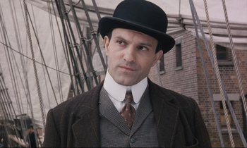Movie still from “Maurice” (1987), directed by James Ivory – A man wearing a suit and a top hat; Close Up shot, Low angle