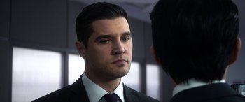 Movie still from “Mayhem” (2017), directed by Joe Lynch – A person wearing a suit and tie; Close Up shot, Over the shoulder angle