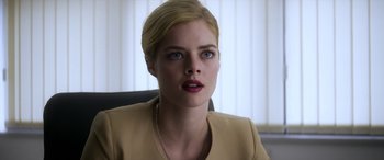 Movie still from “Mayhem” (2017), directed by Joe Lynch – A woman with blonde hair sitting at a desk; Close Up shot, Over the shoulder angle