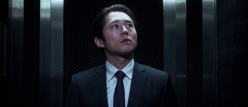 Movie still from “Mayhem” (2017), directed by Joe Lynch – A man wearing a suit and tie standing in front of an elevator; Close Up shot, Low angle